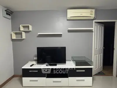 Modern living room with sleek TV stand and wall-mounted shelves, featuring air conditioning for comfort.