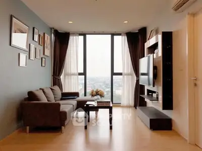 Modern living room with large windows and city view, stylish decor and comfortable seating.