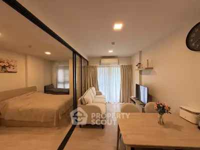 Modern studio apartment with open layout, featuring cozy living area, dining space, and bedroom with glass partition.