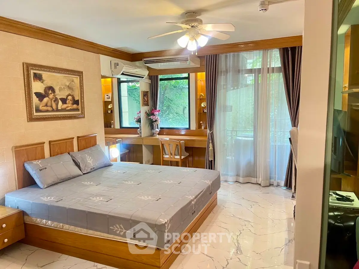 Spacious bedroom with elegant decor and large windows offering natural light and garden view.