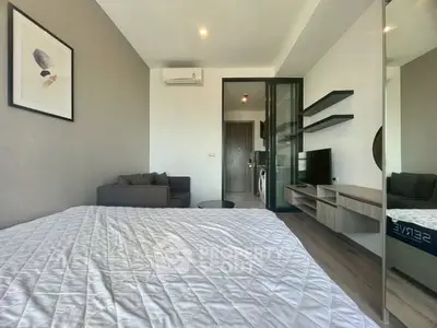 Modern bedroom with stylish decor and open layout, featuring a cozy living area and sleek furnishings.