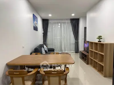 Modern living room with elegant dining set and cozy sofa, perfect for family gatherings.