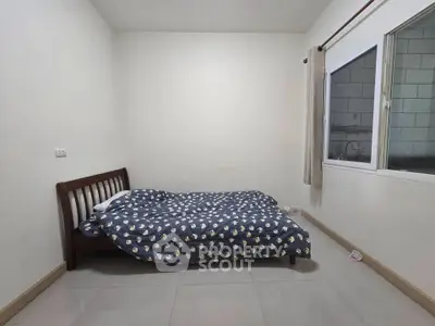Minimalist bedroom with simple bed and window, perfect for cozy living.