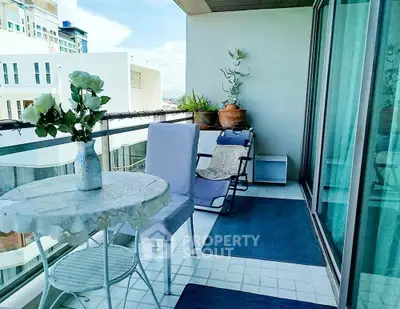 Charming balcony with cozy seating and city view, perfect for relaxation and entertaining.