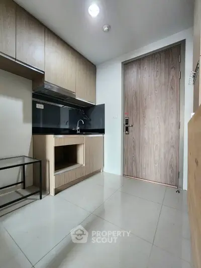 Modern compact kitchen with sleek wooden cabinets and glossy floor tiles