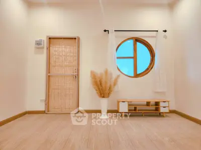 Minimalist living room with round window and elegant decor