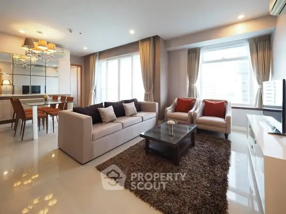 Spacious modern living room with elegant decor and large windows offering city views.