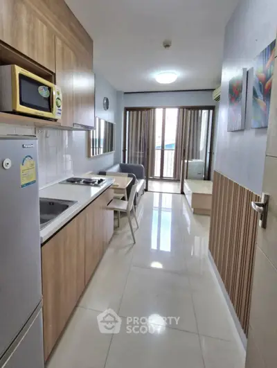 Modern kitchen with open layout and cozy living area in a stylish apartment.