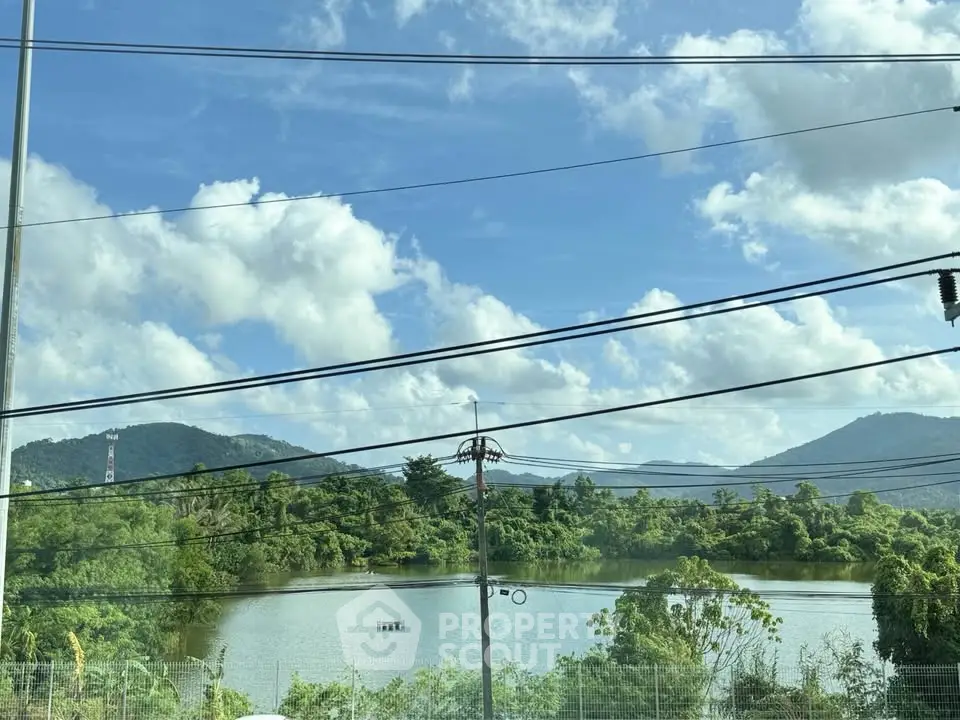 Scenic view of lush greenery and serene lake from a property window, perfect for nature lovers.