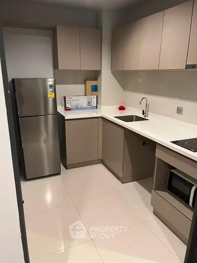 Modern kitchen with sleek cabinetry and stainless steel appliances in a contemporary apartment.