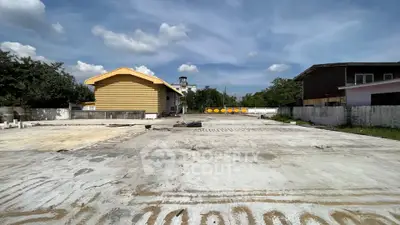 Spacious industrial property with large concrete yard and warehouse building.