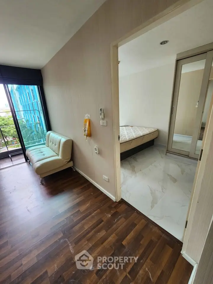 Modern apartment with wooden flooring and cozy bedroom, featuring a small balcony with city view.