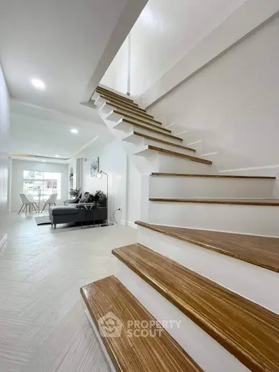 Modern interior with stylish staircase and cozy living area, perfect for contemporary living.