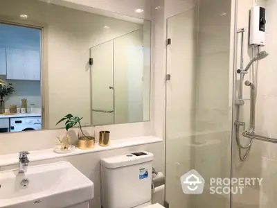 Modern bathroom with a sleek glass shower enclosure, well-lit vanity area, and pristine fixtures, perfect for a refreshing start to the day.