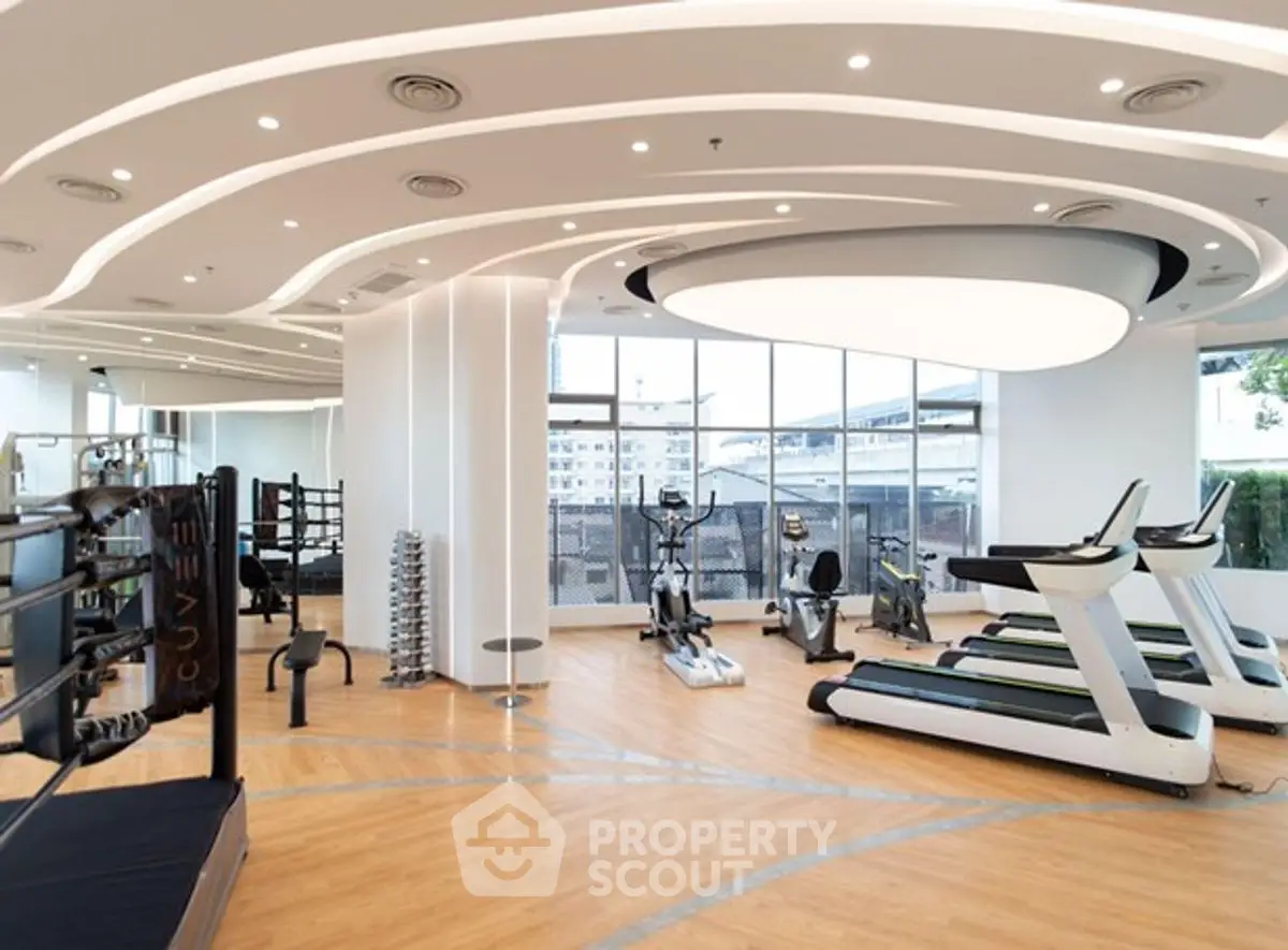 Modern gym with state-of-the-art equipment and large windows for natural light.