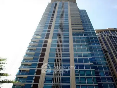 Stunning high-rise building with modern glass facade and multiple balconies in urban setting.