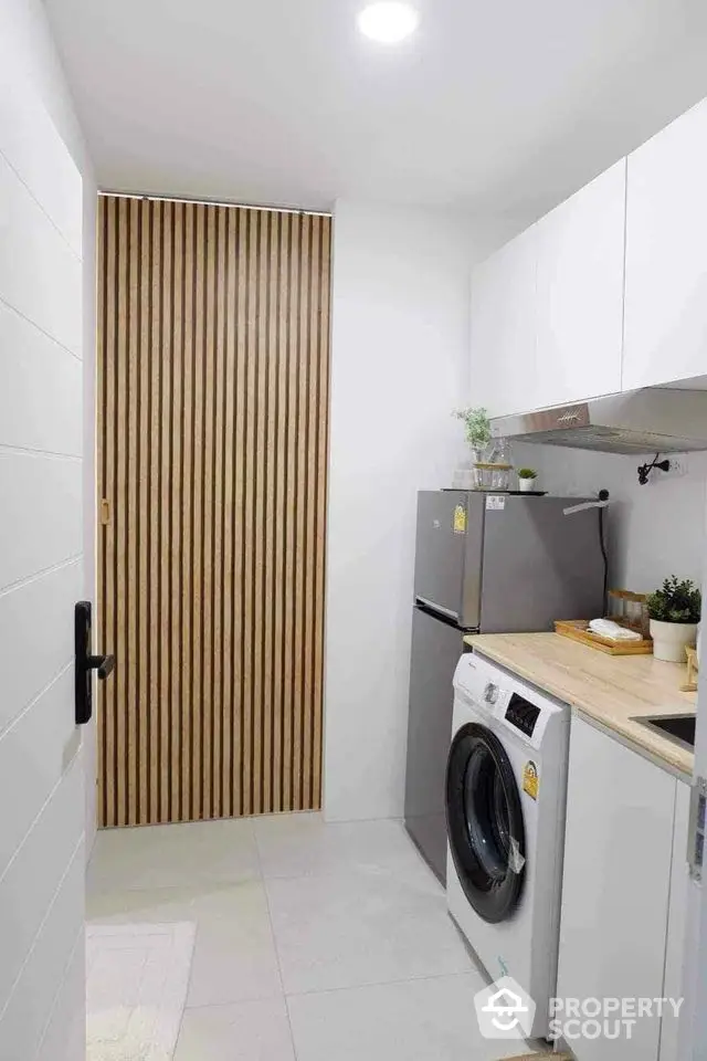 Modern kitchen with washing machine and fridge in sleek minimalist design