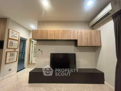 Modern living room with sleek TV unit and air conditioning, perfect for cozy entertainment.