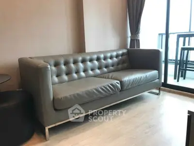 Modern living room with sleek leather sofa and balcony view