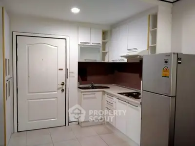 Modern kitchen with sleek white cabinets and stainless steel fridge