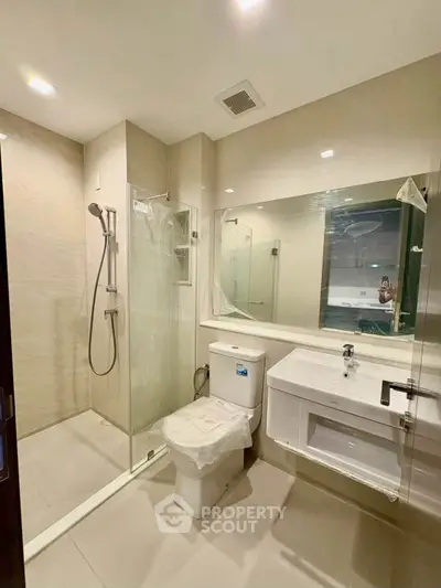 Modern bathroom with glass shower and sleek fixtures in a contemporary apartment.