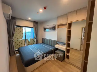 Modern bedroom with large window and stylish decor in a contemporary apartment.