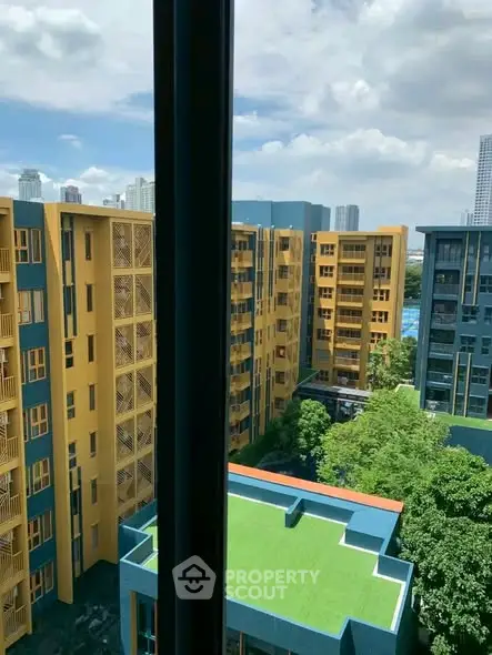 Modern urban apartment complex with vibrant yellow and blue facades, offering a scenic city view.