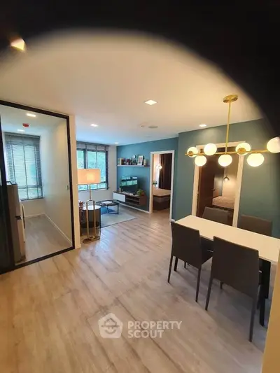 Modern open-plan living and dining area with stylish lighting and cozy decor