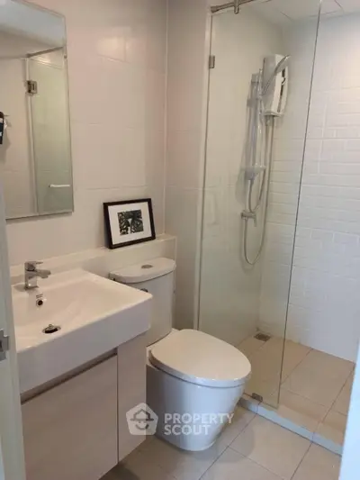 Modern bathroom with glass shower and sleek fixtures in a contemporary apartment.