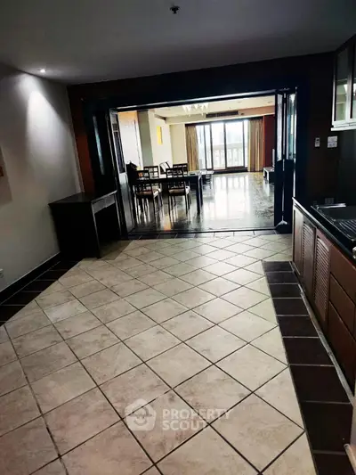 Spacious open-plan living area with tiled flooring and natural light