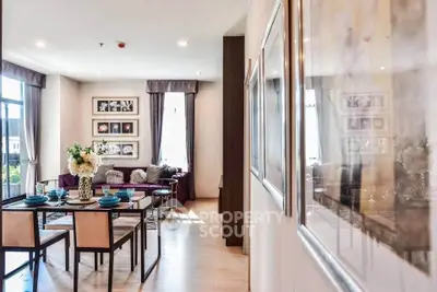 Elegant living room with dining area, modern decor, and large windows for natural light.