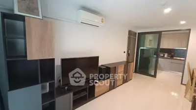 Modern living room with sleek furniture and open kitchen layout in a stylish apartment.