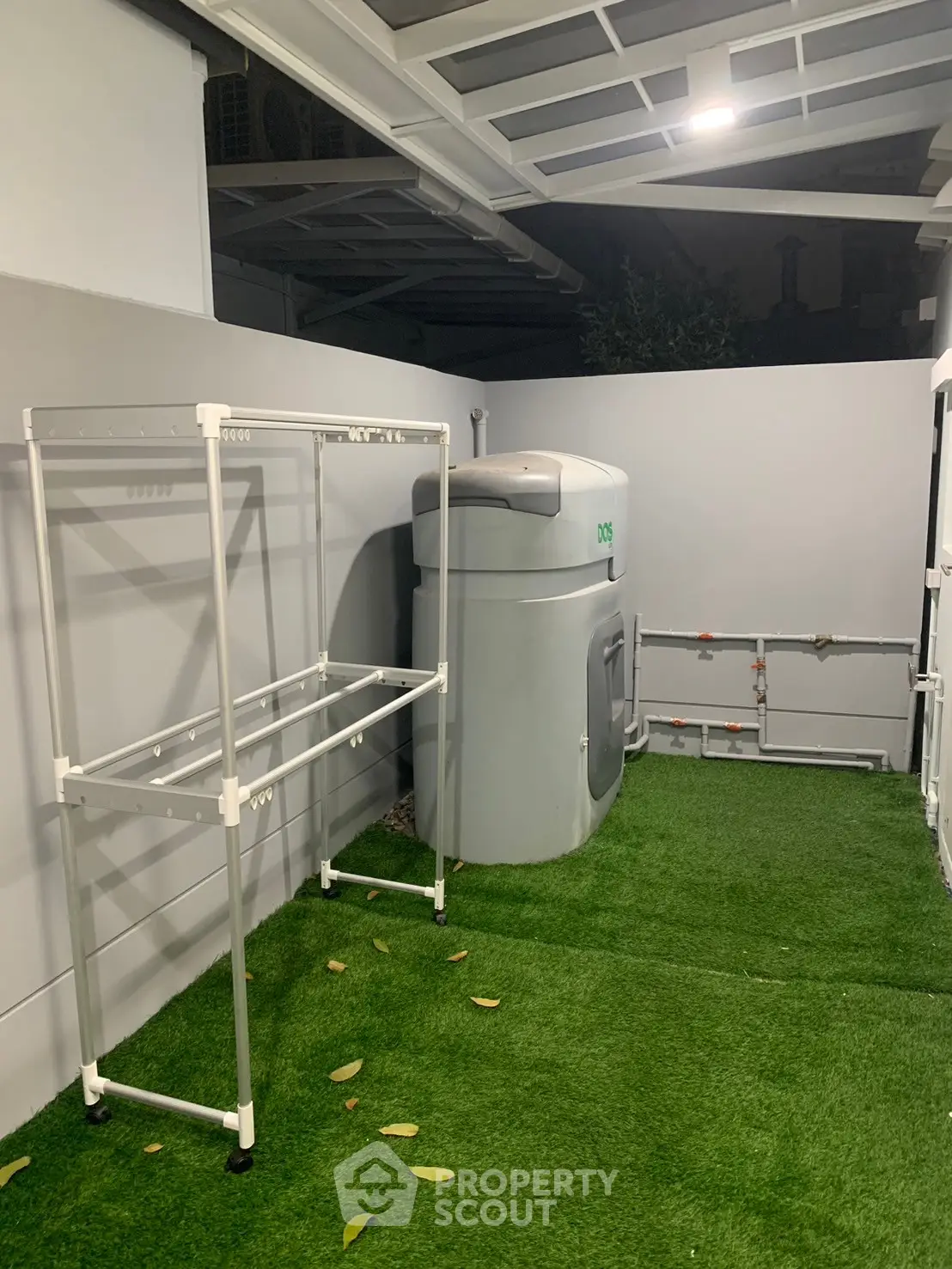 Modern outdoor utility area with artificial grass and storage tank