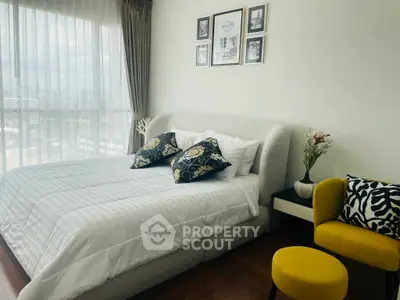 Luxurious bedroom with elegant decor and large window offering natural light.