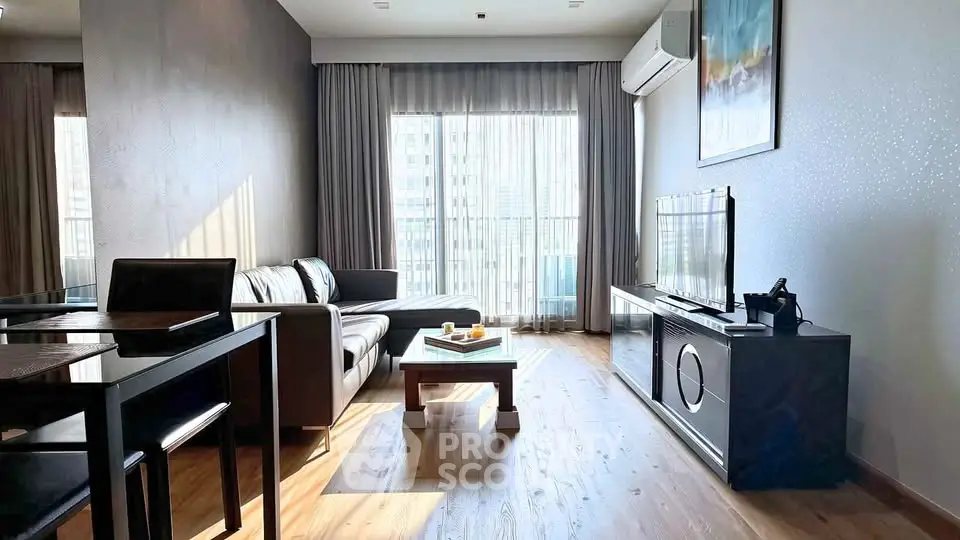 Modern living room with sleek furniture and large window offering natural light.