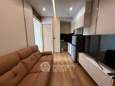 Modern living room with sleek kitchen and cozy brown sofa