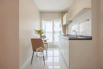 Bright kitchen with sleek design and balcony view, perfect for modern living.