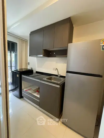 Modern kitchen with sleek cabinets and stainless steel appliances in a cozy apartment.