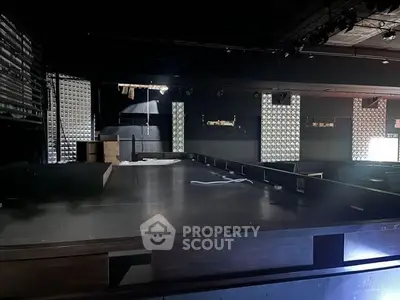 Spacious commercial interior with stage and modern design elements.