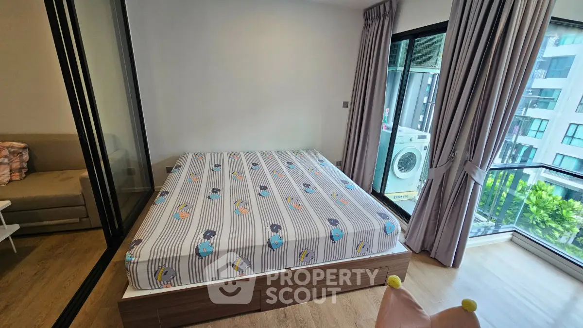 Modern bedroom with large windows and balcony view, featuring a cozy bed and stylish decor.