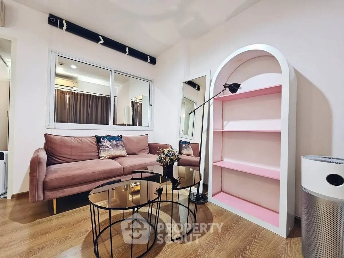 Chic living room with pink sofa, modern decor, and stylish shelving