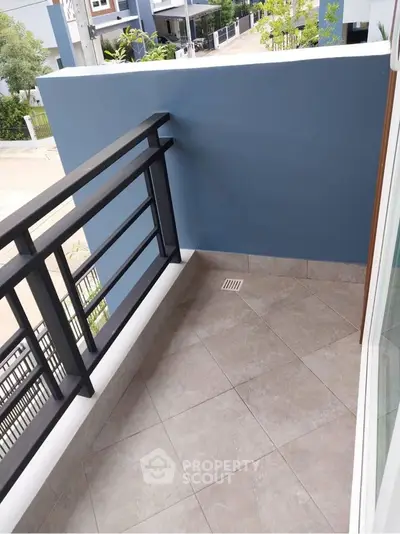 Charming small balcony with modern railing and tiled floor in urban setting.