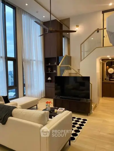 Luxurious modern living room with high ceilings and large windows offering stunning city views.