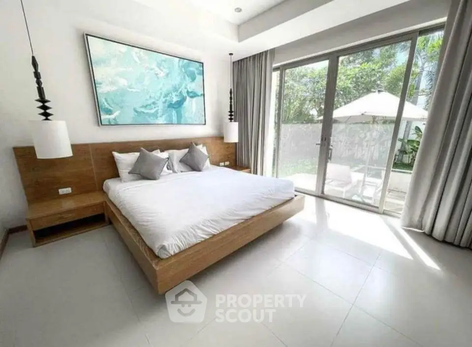Spacious bedroom with modern decor and large window overlooking garden
