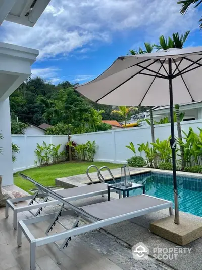 Luxurious poolside view with lush garden and stylish loungers in tropical setting