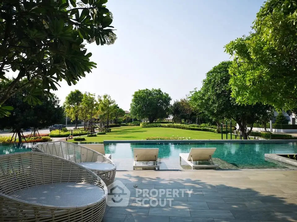 Luxurious outdoor pool area with lush garden views and stylish seating, perfect for relaxation and leisure.