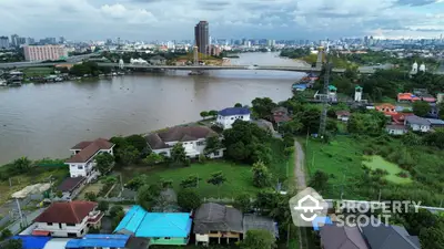 Stunning riverfront view with lush greenery and city skyline, ideal for real estate investment.