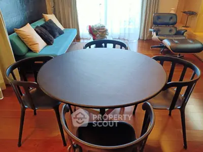 Stylish living room with modern furniture and elegant decor, featuring a round dining table and comfortable seating.