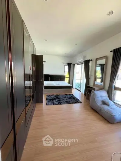 Spacious modern bedroom with large windows and sleek furnishings