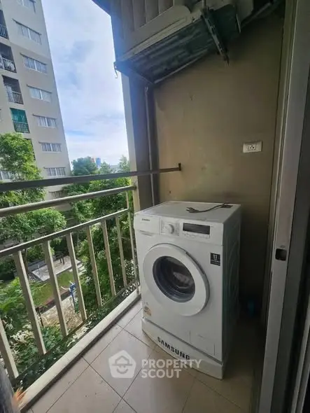 Compact balcony with washing machine and urban view